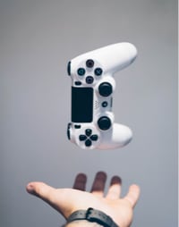 A left hand throwing a white game controller in the air